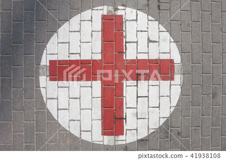 Sign of the medical red cross on the sidewalk 41938108