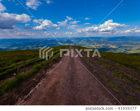tropped mountain road leading down to the plain. A tropped mountain road leading down to the plain. A 41938377