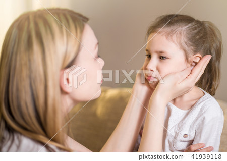Beautiful mother is comforting his young frustrated daughter. Beautiful mother is comforting his young frustrated daughter. 41939118