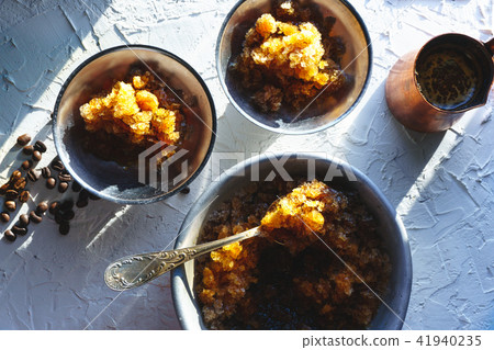Dish for dessert with coffee ice, a bowl and grains on the table top view. Sicilian granite 41940235