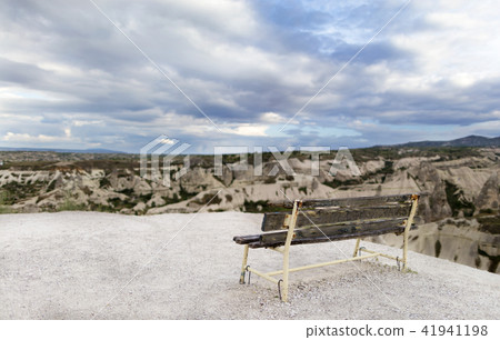 A wooden weathered bench stands against A wooden weathered bench stands against 41941198