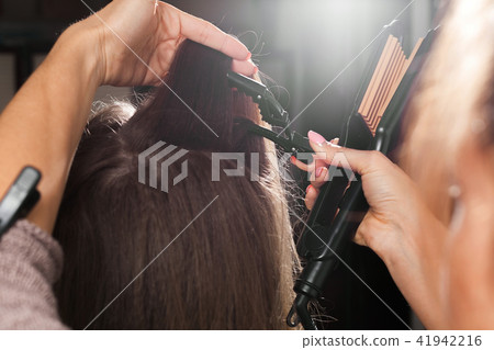 hairdresser clipping hair of a model before making a gauffer hairdresser clipping hair of a model before making a gauffer 41942216