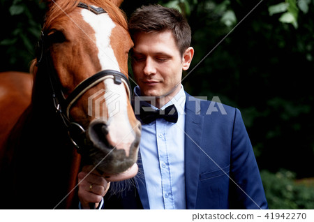 Wedding romantic walk of the bride and groom.Brown horse.Portrait of groom 41942270