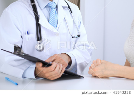 Doctor and patient talking while sitting at the table . Concept of support and trust in medicine Doctor and patient talking while sitting at the table . Concept of support and trust in medicine 41943238