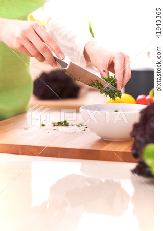 Close Up of human hands cooking vegetable salad in kitchen on the glass table with reflection Close Up of human hands cooking vegetable salad in kitchen on the glass table with reflection 41943365