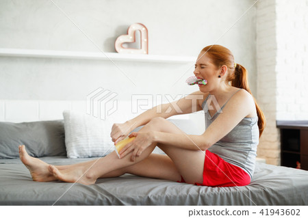 Redhead Woman Feeling Pain Waxing Her Legs 41943602