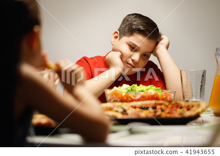 Mother Giving Salad Instead Of Pizza To Overweight Son 41943655