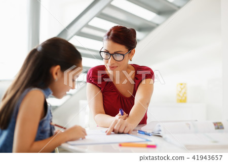 Education With Mom Helping Daughter Doing School Homework At Home 41943657