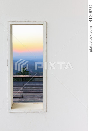 White wall window with sunset mountain view. 41949783