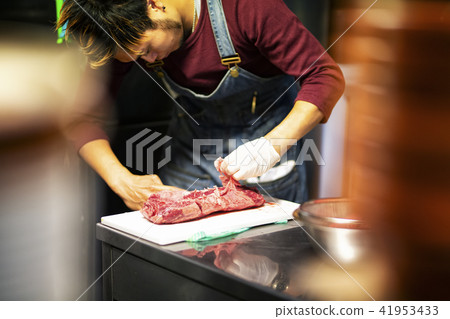 A man who prepares meat dishes 41953433