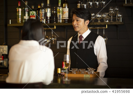 Women in their 20s drinking at a bar 41955698