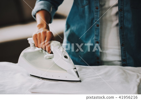 Close up. Young Girl in Jean Shirt Ironing Cloth. 41956216