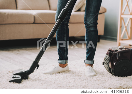 Close up. Woman Cleans Carpet with Vacuum Cleaner.