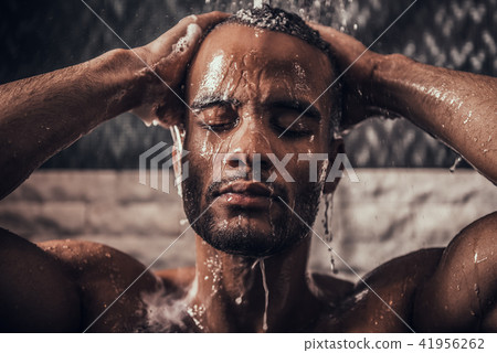 Young Afro-American Man Taking Shower in Bathroom. Young Afro-American Man Taking Shower in Bathroom. 41956262