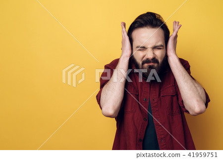 Portrait of Concerned Attractive Man Covering Ears Portrait of Concerned Attractive Man Covering Ears 41959751