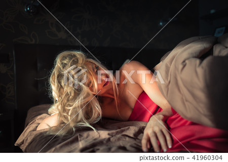 Gorgeous blonde girl wake up in the bed and relaxes at early morning 41960304