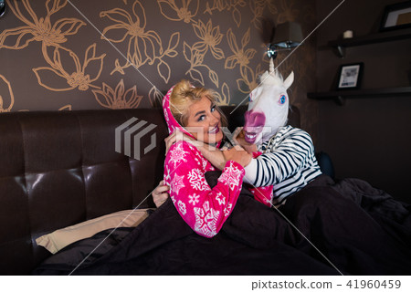 Happy young woman in pajama is lying on the bed with funny boyfriend 41960459