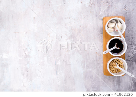 spice pine nuts, soy sauce and garlic on a bowl gray stone background with copy space spice pine nuts, soy sauce and garlic on a bowl gray stone background with copy space 41962120
