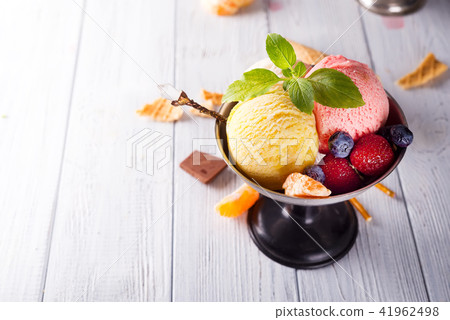 Homemade Organic Vanilla Ice Cream with Mint and ice berries on wooden background Homemade Organic Vanilla Ice Cream with Mint and ice berries on wooden background 41962498