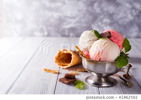 Homemade Organic Vanilla Ice Cream with Mint and ice berries on wooden background Homemade Organic Vanilla Ice Cream with Mint and ice berries on wooden background 41962502
