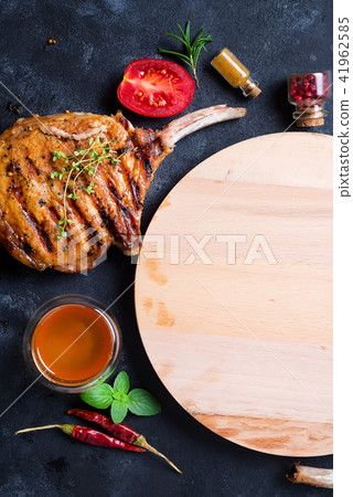 Grilled T-bone steak on stone table with wooden board. Top view with copy space Grilled T-bone steak on stone table with wooden board. Top view with copy space 41962585