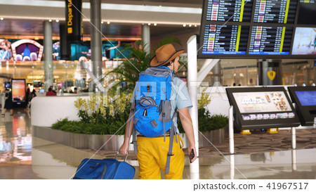 International airport tourist passenger goes to checking timetable, check carefully schedules of International airport tourist passenger goes to checking timetable, check carefully schedules of 41967517