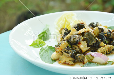 spicy golden apple snail with herb salad on plate spicy golden apple snail with herb salad on plate 41968986