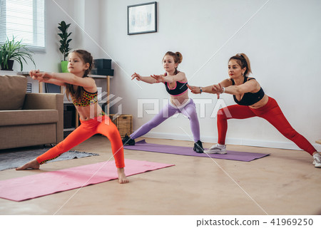 Women squatting and stretching legs doing squat exercises working on butt muscles Women squatting and stretching legs doing squat exercises working on butt muscles 41969250