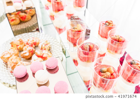Candy bar with a lot of desserts, meringue, cupcake, fruit and sweet cakes. Sweet table for birthday 41971674