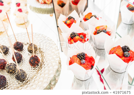 Candy bar with a lot of desserts, meringue, cupcake, fruit and sweet cakes. Sweet table for birthday Candy bar with a lot of desserts, meringue, cupcake, fruit and sweet cakes. Sweet table for birthday 41971675