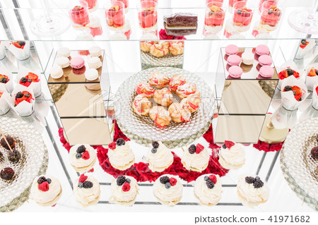 Candy bar with a lot of desserts, meringue, cupcake, fruit and sweet cakes. Sweet table for birthday Candy bar with a lot of desserts, meringue, cupcake, fruit and sweet cakes. Sweet table for birthday 41971682