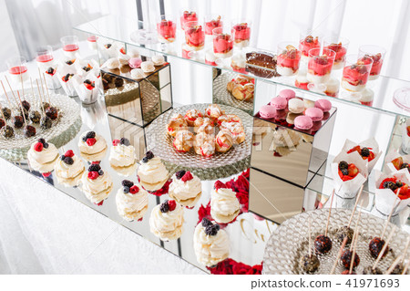 Candy bar with a lot of desserts, meringue, cupcake, fruit and sweet cakes. Sweet table for birthday Candy bar with a lot of desserts, meringue, cupcake, fruit and sweet cakes. Sweet table for birthday 41971693
