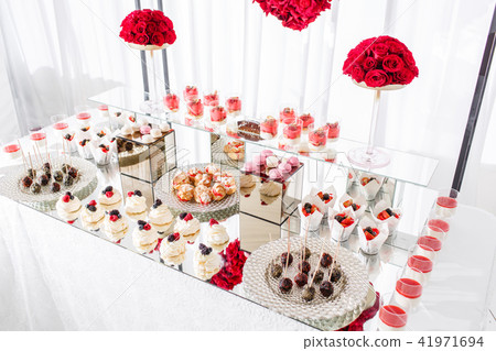 Candy bar with a lot of desserts, meringue, cupcake, fruit and sweet cakes. Sweet table for birthday Candy bar with a lot of desserts, meringue, cupcake, fruit and sweet cakes. Sweet table for birthday 41971694