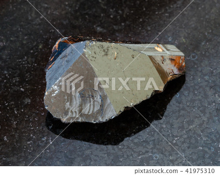 raw crystal of Cassiterite stone on black raw crystal of Cassiterite stone on black 41975310