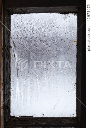water from melting ice on surface of misted window water from melting ice on surface of misted window 41975473
