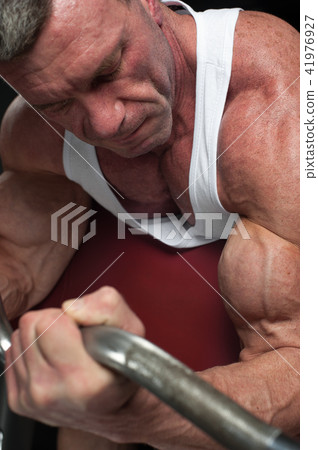 Strong bodybuilder working out with dumbbells 41976927