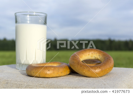 bagels and glass of milk on a meadow background bagels and glass of milk on a meadow background 41977673