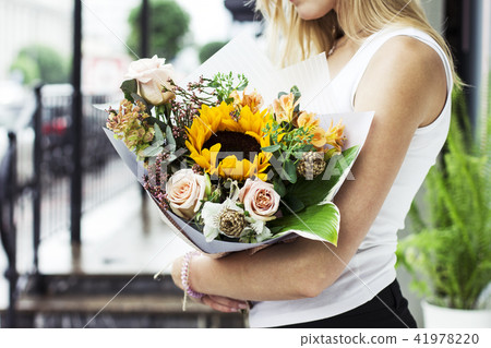 woman with blonde hair holding bouquet of flowers woman with blonde hair holding bouquet of flowers 41978220