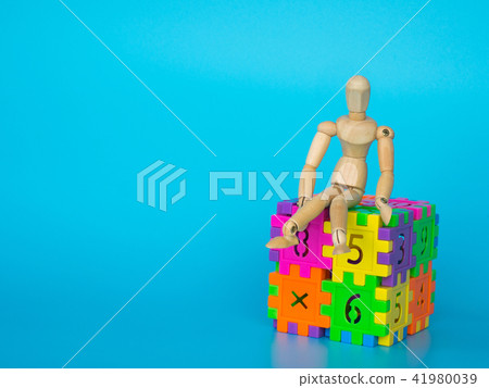Wooden puppet sitting on cube plastic colorful Wooden puppet sitting on cube plastic colorful 41980039