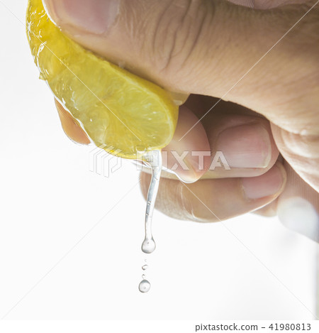 Human hand squeezing half of lemon Human hand squeezing half of lemon 41980813