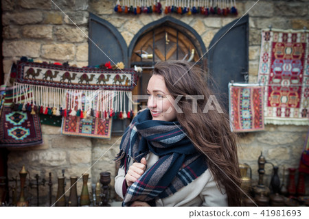 Young woman stands near a beautiful showcase on the eastern market Young woman stands near a beautiful showcase on the eastern market 41981693