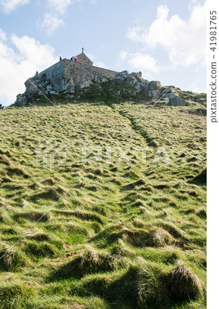 Stone building in a small stone built on the hill near the sea under the blue sky along the coast of the UK suburbs Stone building in a small stone built on the hill near the sea under the blue sky along the coast of the UK suburbs 41981765