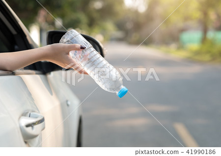 Hand throwing plastic bottle on the road Hand throwing plastic bottle on the road 41990186