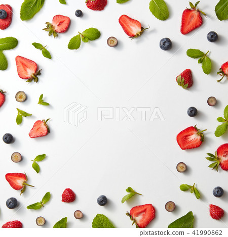 A pattern of strawberries and blueberries with mint on a gray background. Berry frame. Flat lay 41990862