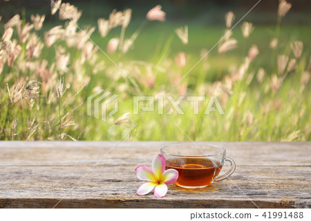 Red tea and frangipani flower on wooden table 41991488
