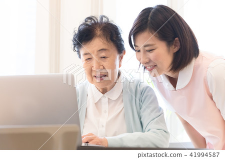 高級筆記本電腦操作的女人和照顧者 高級筆記本電腦操作的女人和照顧者 41994587