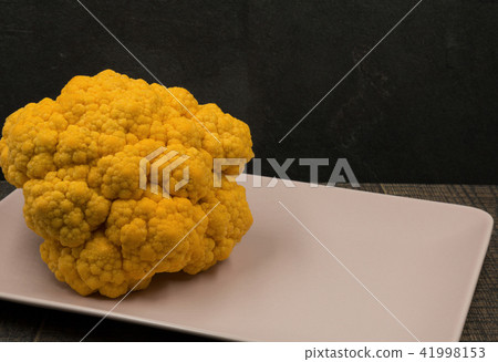 Yellow cauliflower on a pink platter Yellow cauliflower on a pink platter 41998153