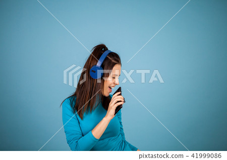Cute young woman singing on her phone while dancing Cute young woman singing on her phone while dancing 41999086