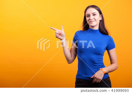 Smilling pretty woman pointing away 41999093