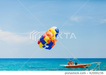 Couple of tourists flying on a colorful parachute 42000236